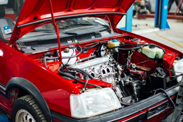 Открытый капот автомобиля для проверки запаха гари